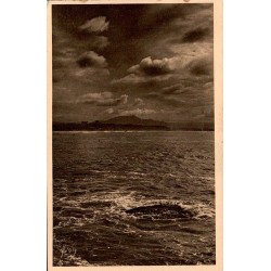 Carte postale ancienne de Biarritz montrant un ciel d'orage sur la Côte des Basques avec la Rhune à l'horizon.