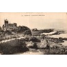 Carte postale ancienne de Biarritz montrant les rochers à marée basse et une villa dominant les falaises.