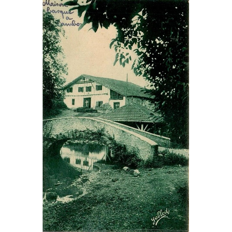 Carte postale ancienne d'une maison basque au Vieux Cambo avec un petit pont de pierre sur un ruisseau.