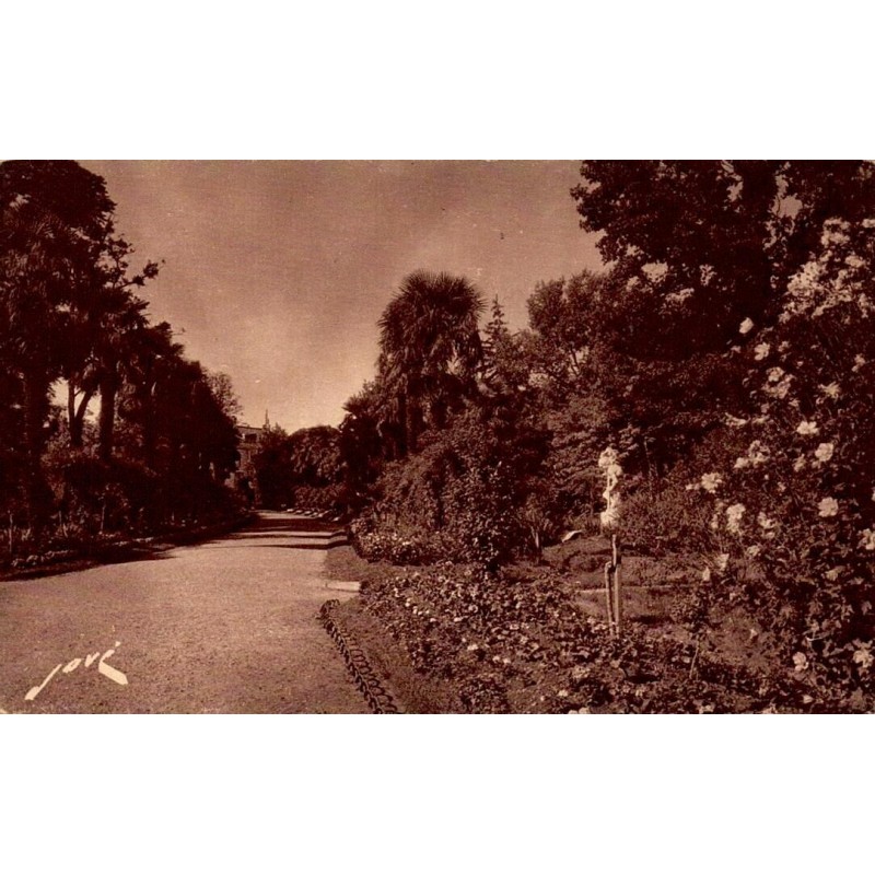 Carte postale ancienne de Tarbes montrant les allées fleuries du Jardin Massey et la statue de Saint-Christophe.