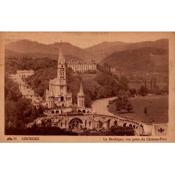 Carte postale ancienne de Lourdes montrant la basilique vue depuis le Château-Fort, oblitérée en 1951.