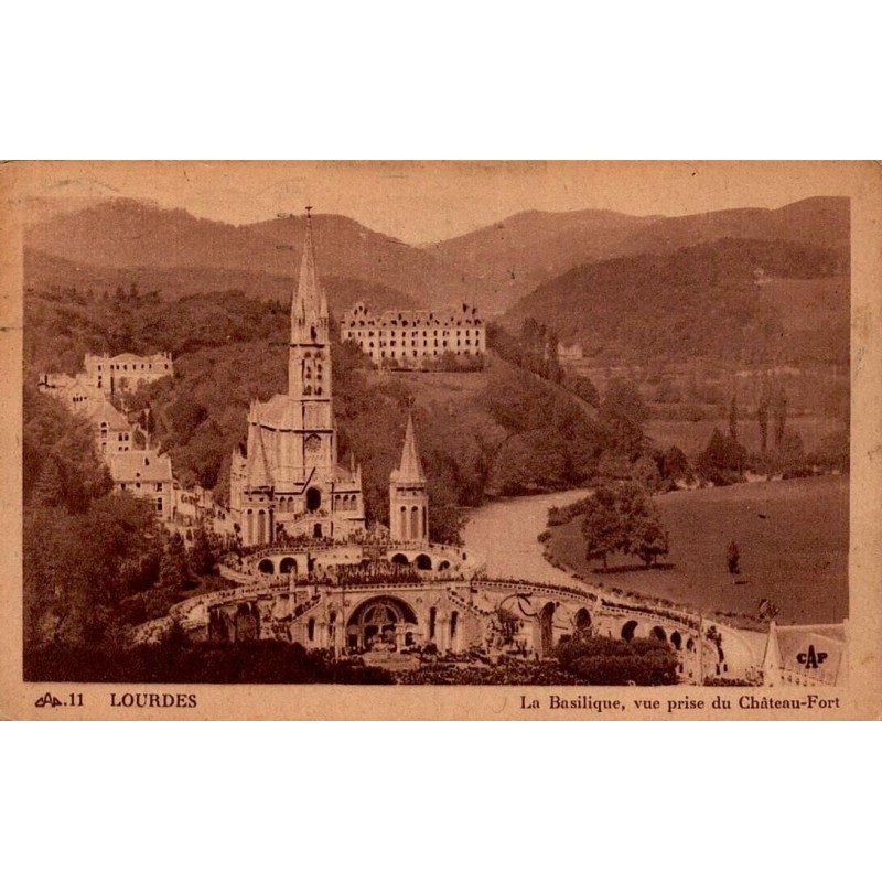 Carte postale ancienne de Lourdes montrant la basilique vue depuis le Château-Fort, oblitérée en 1951.