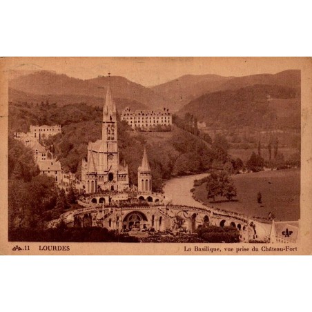 Carte postale ancienne de Lourdes montrant la basilique vue depuis le Château-Fort, oblitérée en 1951.