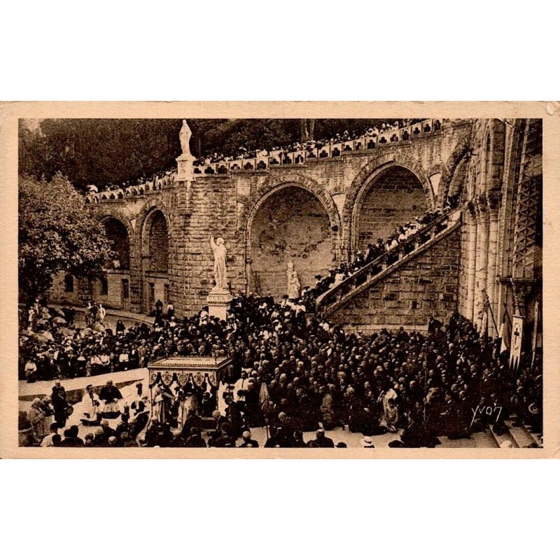 Carte postale ancienne de Lourdes montrant le départ du Saint-Sacrement devant la basilique lors d'un pèlerinage.
