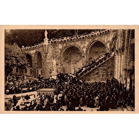 Carte postale ancienne de Lourdes montrant le départ du Saint-Sacrement devant la basilique lors d'un pèlerinage.