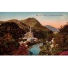 Carte postale ancienne en couleurs de Lourdes montrant la basilique et le Gave avec les Pyrénées en arrière-plan