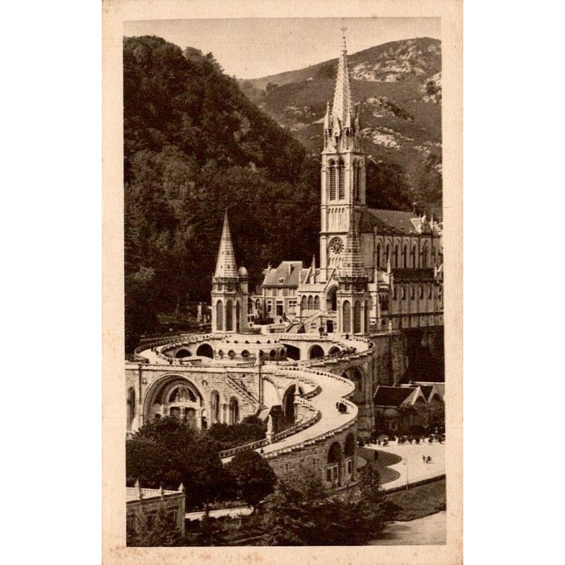 Carte postale ancienne de Lourdes montrant la basilique et les rampes du sanctuaire au bord du Gave