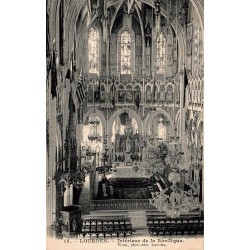 Carte postale ancienne montrant l'intérieur de la basilique de Lourdes avec la nef, les vitraux et le maître-autel.