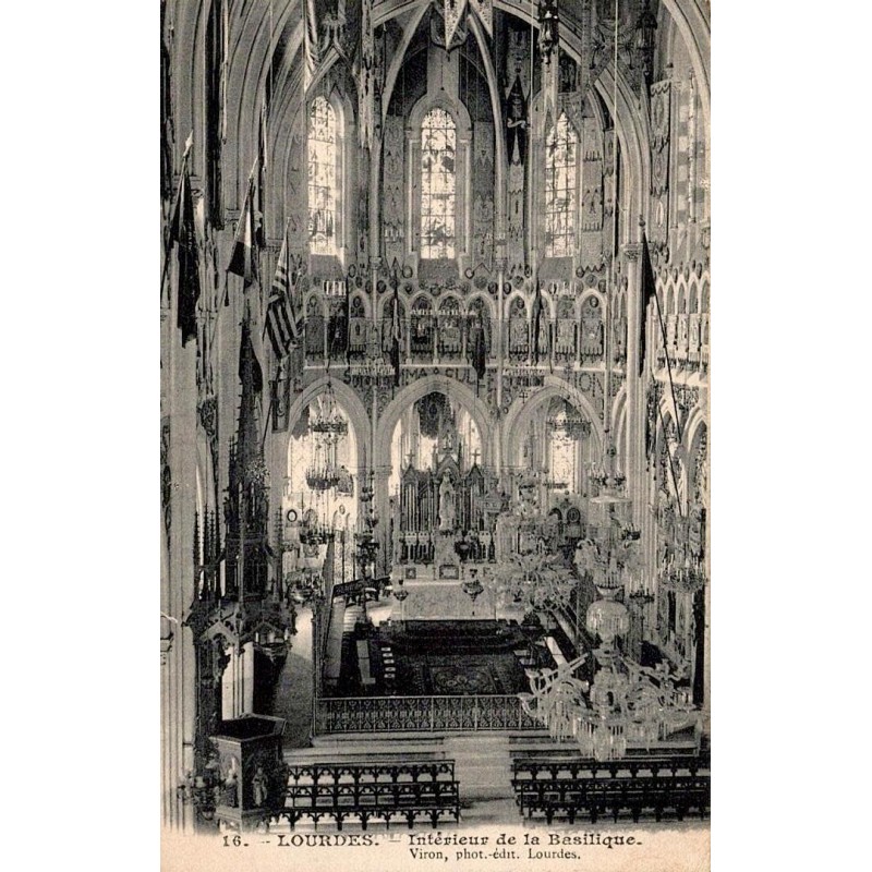 Carte postale ancienne montrant l'intérieur de la basilique de Lourdes avec la nef, les vitraux et le maître-autel.