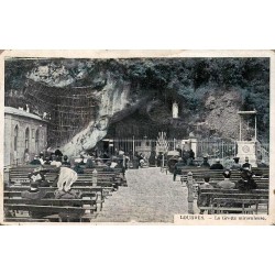 Carte postale ancienne de Lourdes montrant la Grotte miraculeuse animée par les pèlerins.
