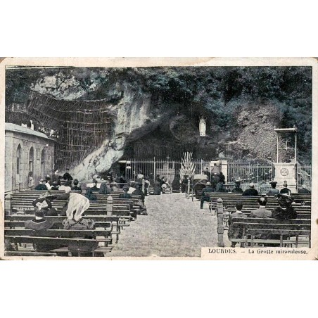 Carte postale ancienne de Lourdes montrant la Grotte miraculeuse animée par les pèlerins.