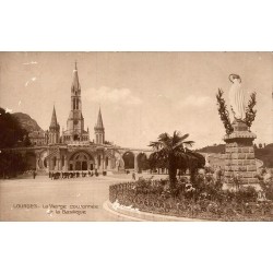 Carte postale ancienne de Lourdes montrant la Vierge couronnée devant la basilique du sanctuaire.