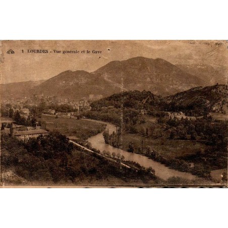 Carte postale ancienne de Lourdes montrant une vue générale de la ville et du Gave de Pau avec les Pyrénées en arrière-plan.