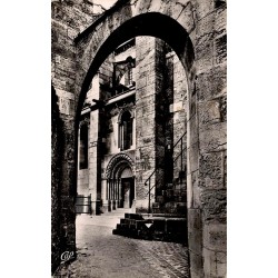 Carte postale ancienne de Langres montrant un coin médiéval avec arche de pierre et portail roman.