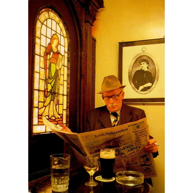 Carte postale moderne de Kitty O'Shea's Bar à Dublin montrant un client lisant son journal devant une pinte de stout.