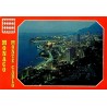 Carte postale moderne représentant une vue nocturne panoramique de Monte-Carlo avec le port illuminé et le littoral monégasque.