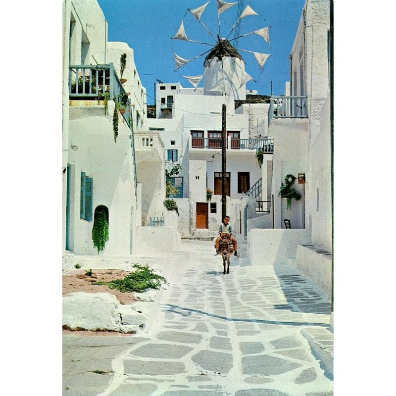 Carte Postale Moderne représentant une ruelle pittoresque de Mykonos avec un moulin à vent et un enfant sur un âne.