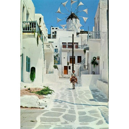 Carte Postale Moderne représentant une ruelle pittoresque de Mykonos avec un moulin à vent et un enfant sur un âne.