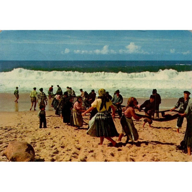 Carte postale CPSM de Nazaré montrant les pêcheurs halant les filets sur la plage au Portugal