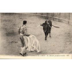CPA corrida montrant un matador exécutant une passe de muleta face à un taureau portant des banderilles