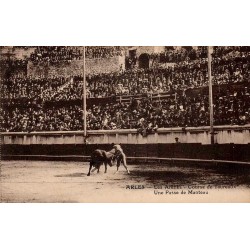CPA Arles montrant un torero exécutant une passe de manteau dans les arènes devant une foule dense