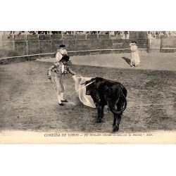 CPA corrida montrant un matador provoquant avec sa muleta un taureau portant des banderilles