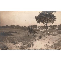 CPA non localisée montrant un cavalier à cheval dans un paysage rural avec habitations