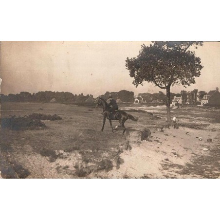 CPA non localisée montrant un cavalier à cheval dans un paysage rural avec habitations