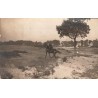 CPA non localisée montrant un cavalier à cheval dans un paysage rural avec habitations
