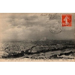 Carte postale ancienne montrant le Sacré-Cœur vu depuis la Tour Eiffel avec un ciel d’orage au-dessus de Paris.