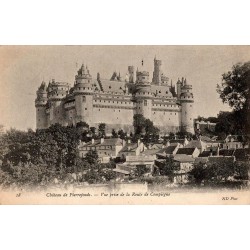 Carte postale ancienne du château de Pierrefonds vue depuis la route de Compiègne avec le village au premier plan.