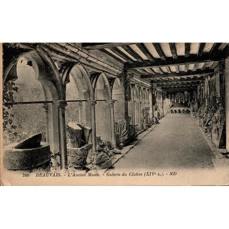 CPA de Beauvais représentant la galerie du cloître de l'ancien musée avec ses arcades gothiques et ses collections lapidaires.