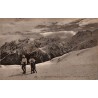 Carte postale ancienne de Superbagnères montrant deux promeneurs face au massif de la Maladeta enneigé.