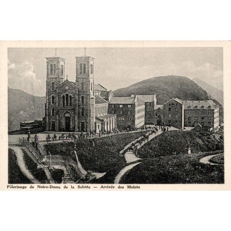 Carte postale ancienne du sanctuaire Notre-Dame de La Salette montrant l'arrivée des mulets devant la basilique.
